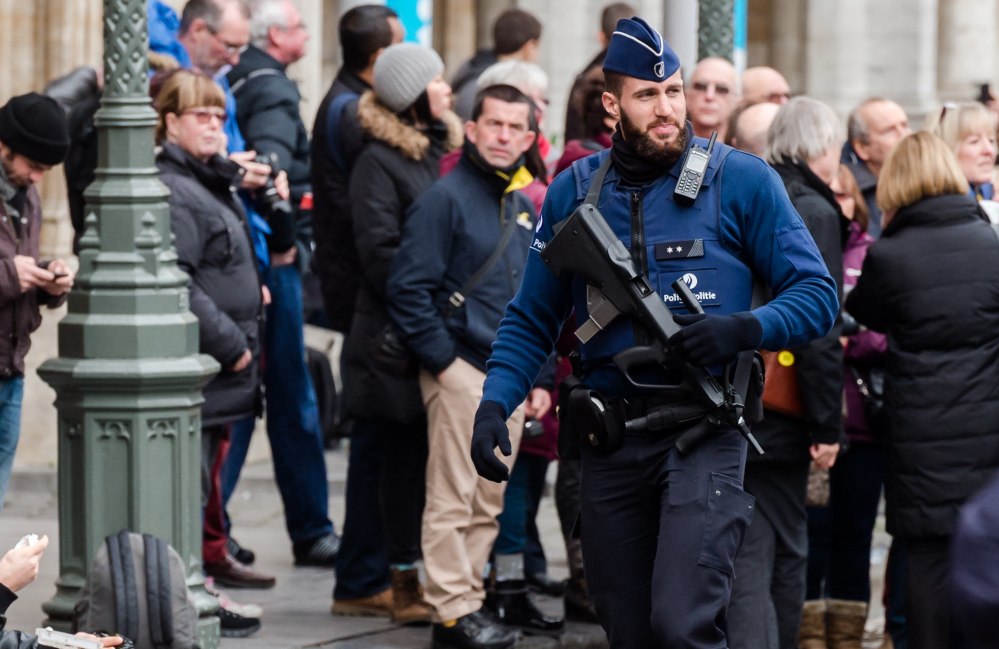 An armed officer patrols at the Grand Place in Brussels on Tuesday after two people were arrested on suspicion of planning attacks during the holidays.
