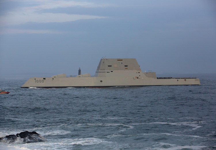 The Zumwalt-class destroyer passes Fort Williams State Park, with Ram Island Ledge Lighthouse in the background, on its way into Portland Harbor on Thursday.