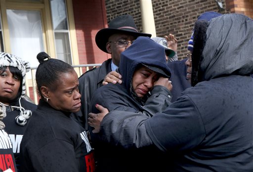 Janet Cooksey, center, the mother of Quintonio LeGrier, is comforted by family and friends during a Sunday news conference to speak out about Saturday's shooting death of her son by the Chicago police. Nancy Stone/Chicago Tribune via AP