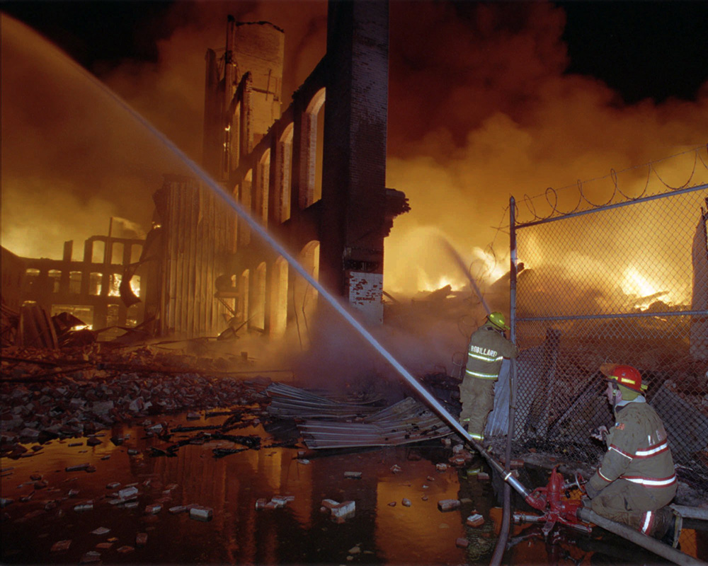 Firefighters pour water onto the burning Malden Mills plant in this Dec. 11, 1995, photo. Thirty-one workers were injured in the fire and explosions, eight critically, according to the state fire marshal. The Associated Press