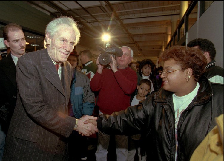 Aaron Feuerstein, then-president and owner of Malden Mills Industries Inc. shakes hands with workers in Lawrence, Mass., in this  Jan. 11, 1996, photo, after he assured them of an extension of their wage and benefit packages for at least another 30 days. An estimated 1,800 workers at the textile mill were left jobless by a December 1995 fire that destroyed several buildings. The Associated Press
