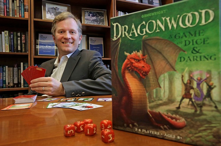 Boston College professor Darren Kisgen poses for a portrait in his office at the college, The game he invented, "Dragonwood," The Associated Press