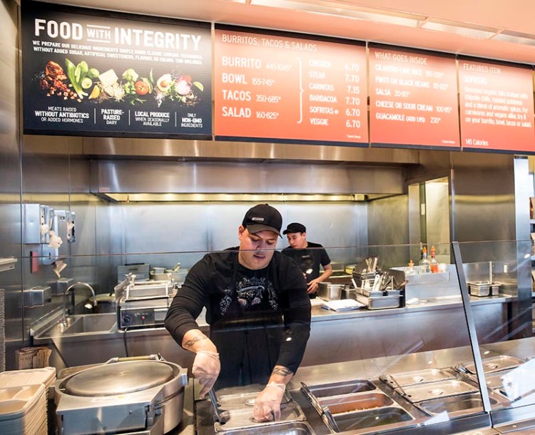 A Chipotle Mexican Grill employee prepares food, in Seattle.