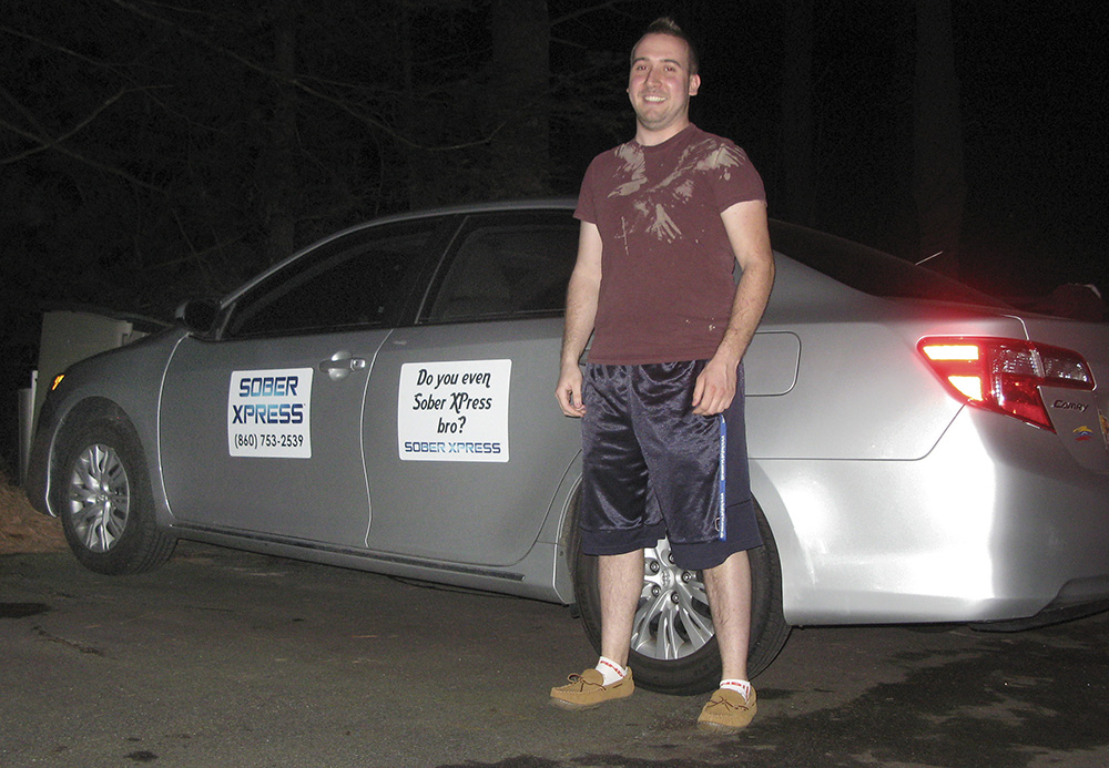 Lance Graziano, 22, with one of the rcars one his Willington, Conn., company uses to provide rides to drunk UConn students on the weekends. The Associated Press