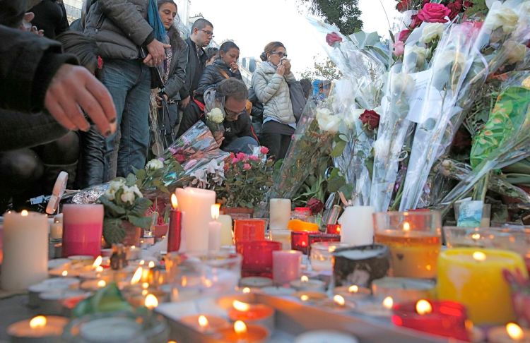 Mourners place flowers and light candles outside the Bataclan concert hall in Paris on Nov. 15. Ninety people died at the concert hall after three gunmen stormed a rock concert by the California band, Eagles of Death Metal. The Associated Press