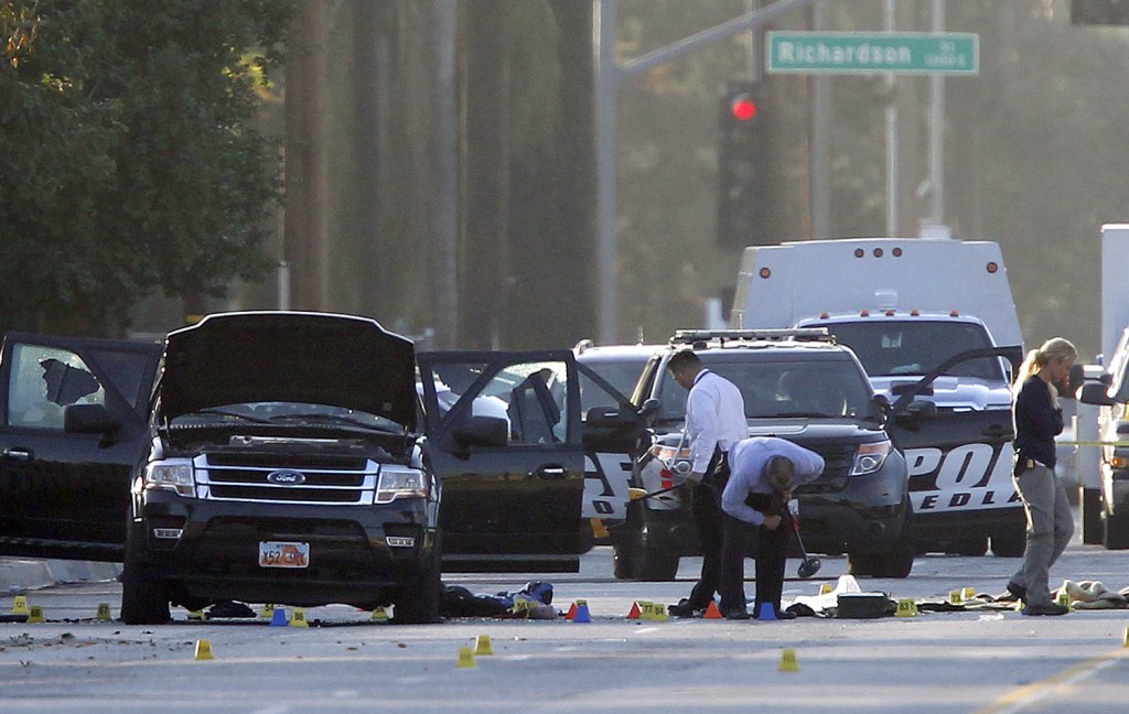 Investigators work Friday around the SUV where the two San Bernardino attackers were killed by police two days earlier. The FBI is investigating the massacre as an "act of terrorism," an official said, saying the female shooter had pledged allegiance to a leader of the Islamic State.  Reuters/Alex Gallardo