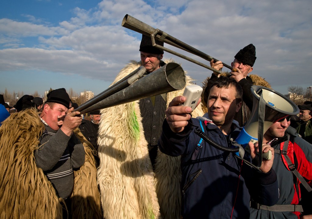 Shepherds try to amplify the sound of horns during a protest in Bucharest, Romania, on Tuesday. 