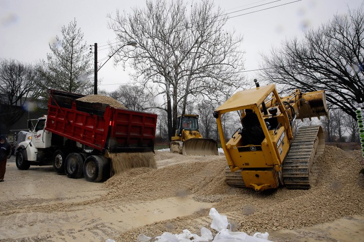 Heavy equipment is used to build a temporary levee to hold back floodwater in Kimmswick, Mo. Missouri Gov. Jay Nixon has declared a state of emergency due to widespread flooding around the state that has closed many roads.