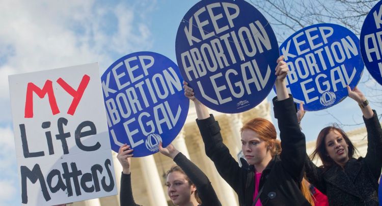 Pro-abortion rights supporters hold up signs in front of the Supreme Court on Jan. 22, 2015, the same day thousands of anti-abortion demonstrators took part in  the annual March for Life to protest the Supreme Court's landmark 1973 decision that declared a constitutional right to abortion. The Associated Press