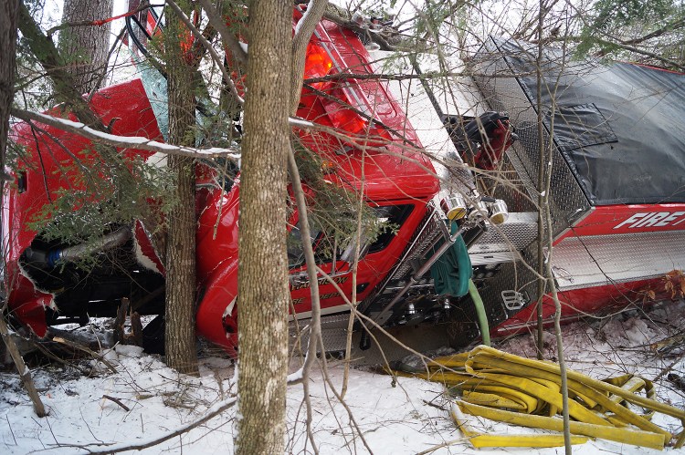 A Harrison firetruck rests against a tree after rolling over on a icy private road. Photo courtesy of Chuck Blaquiere