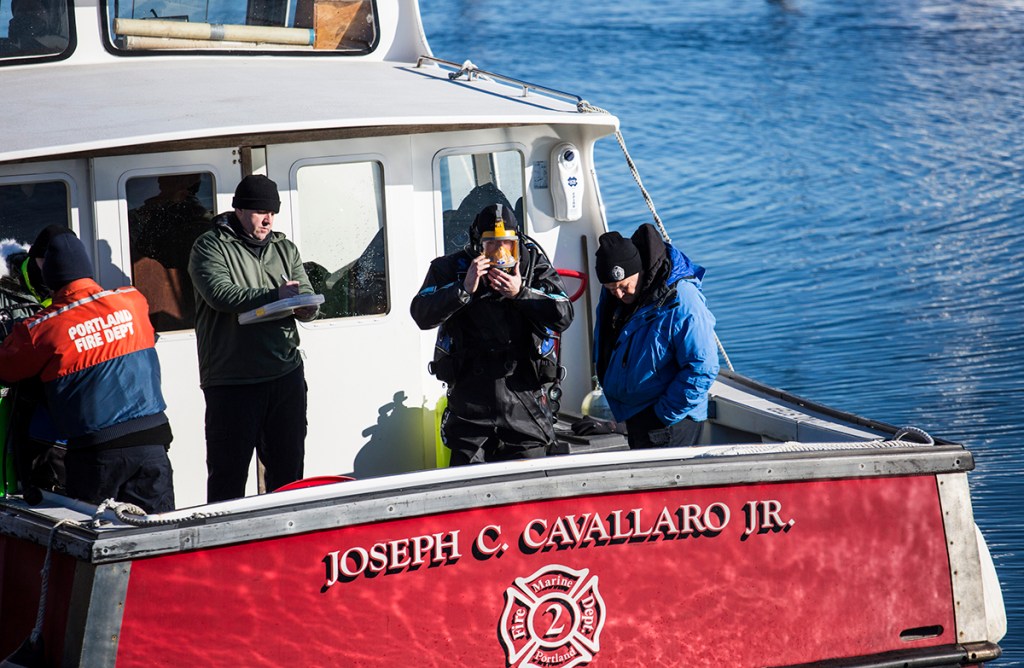 Support personnel assist divers searching the waters for James Dyer near Union Wharf on Tuesday. Whitney Hayward/Staff Photographer