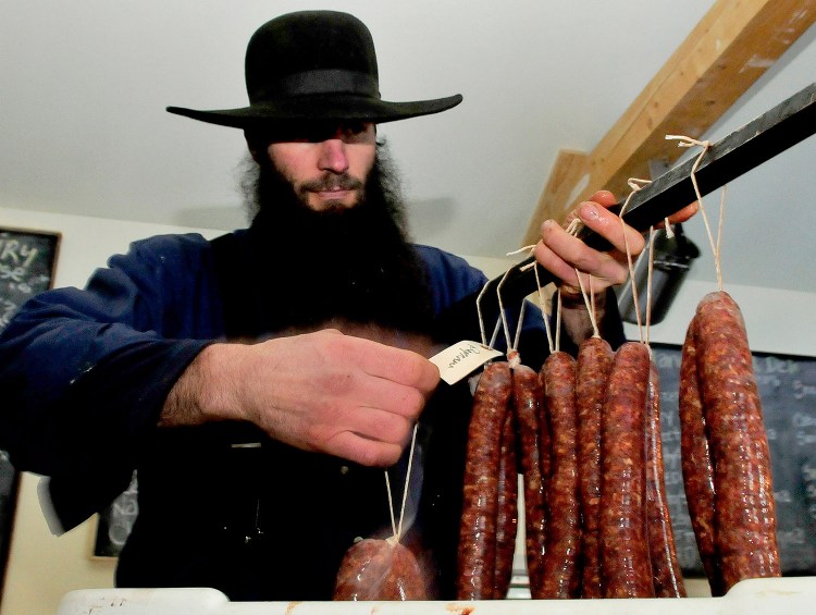 Matt Secich hangs sausages on a bar to dry at his Charcuterie shop in Unity on Wednesday.
David Leaming/Morning Sentinel