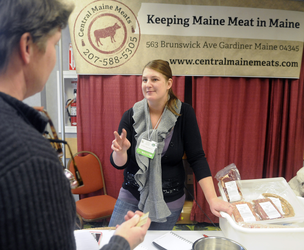 Jen Wade, right, of Central Maine Meats, speaks with Robin Thayer on Tuesday at the Maine Agricultural Trades Show in Augusta.