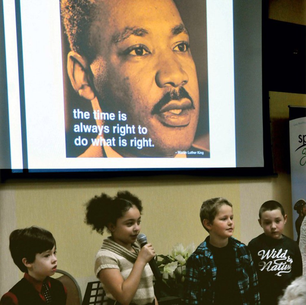 Students from the George Mitchell School, including Isabella Bohner, center, recite passages during the Martin Luther King Jr. breakfast celebration at the Muskie Center in Waterville on Monday.