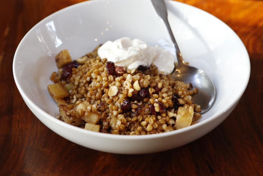 Warm farro breakfast bowl with apples, cranberries and hazelnuts
