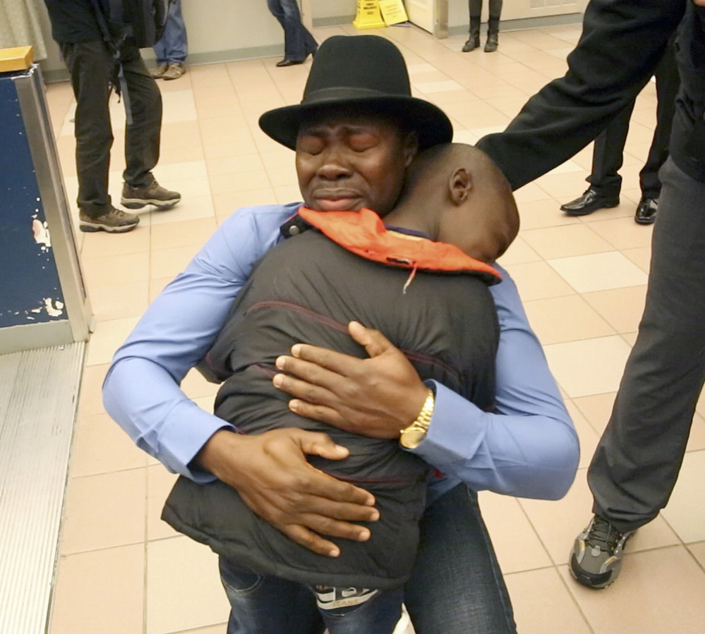 Haroun Adam, 35, embraces his son Mohamed, 9, as his family arrives at the Portland International Jetport on Dec. 17. Adam waited almost five years to be reunited with his wife and four sons.