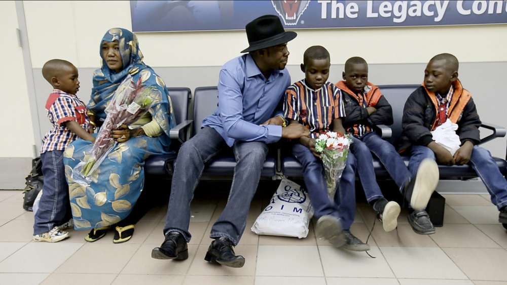 Haroun Adam sits with his wife, Mariam, and family at the Portland International Jetport after they arrived on Dec. 17. His children, from left, are 4-year-old Maaz, 9-year-old twins Motasim and Mohamed and Mortada, 6.