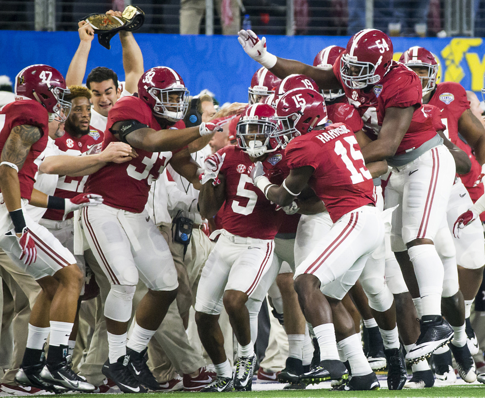 Alabama defensive back Cyrus Jones (5) is mobbed by teammates after intercepting a pass in the Cotton Bowl.