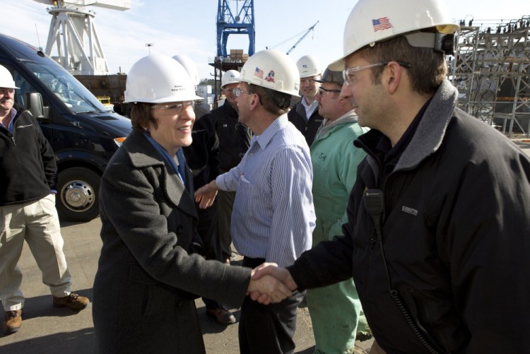 U.S. Sen. Susan Collins greets Bath Iron Works supervisor Chris Comora during a 2013 tour of the shipbuilding plant. A reader says the senator has manipulated the national budget to fund a Navy destroyer.