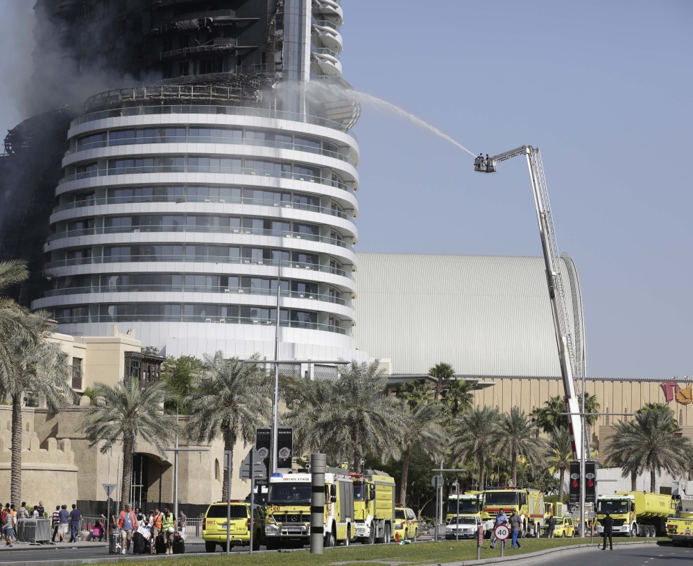 Firefighters spray water on a fire burning in the Address Downtown skyscraper in Dubai, United Arab Emirates, on Friday. The blaze’s cause is under investigation.