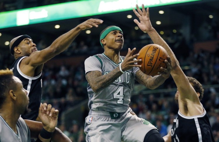 Boston’s Isaiah Thomas goes up to shoot between Brooklyn’s Jarrett Jack, left, and Brook Lopez, right, during the Nets’ 100-97 win Saturday in Boston.