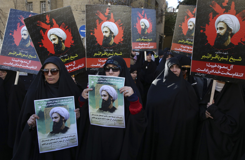 Iranians hold posters of Sheikh Nimr Baqr al-Nimr, a prominent Shiite cleric, during a protest denouncing his execution, in front of the Saudi embassy in Tehran on Sunday. Saudi Arabia executed 47 people, mostly al-Qaida suspects, Saturday.