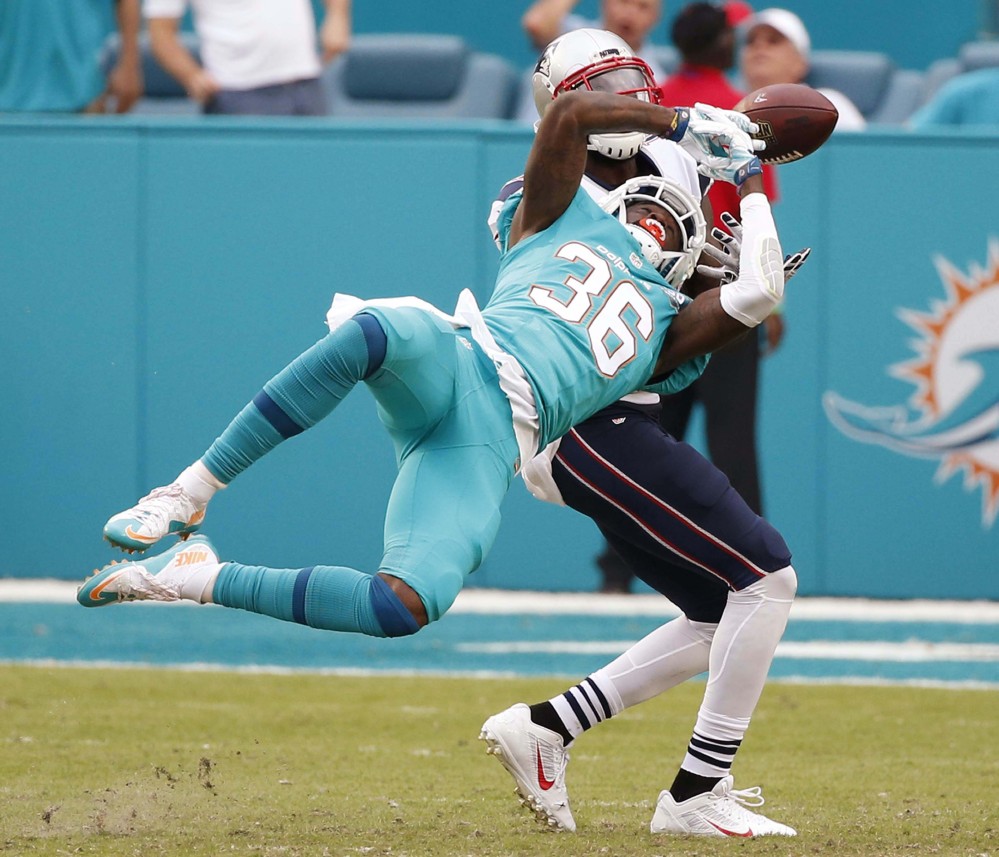 Miami Dolphins defensive back Tony Lippett attempts to intercept a pass intended for New England Patriots wide receiver Brandon LaFell in Sunday’s game.