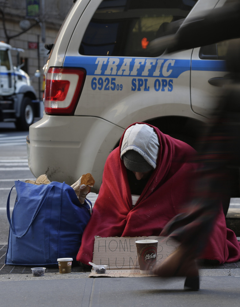 Mike Lago, a homeless man, sits on a New York City sidewalk in freezing conditions Monday.