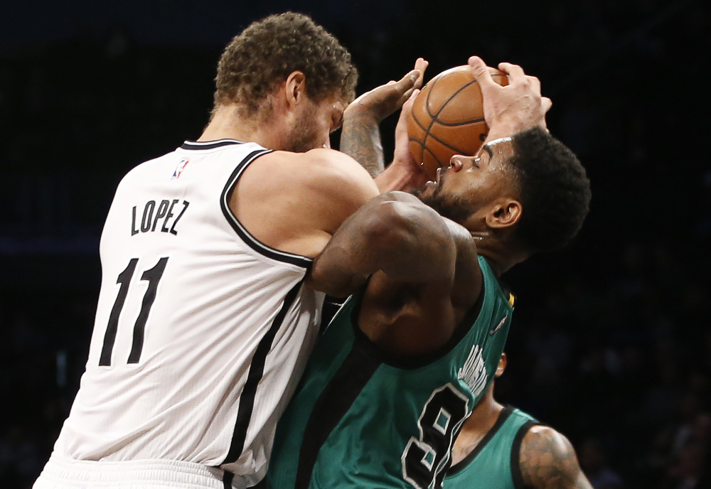 Nets center Brook Lopez and Celtics forward Amir Johnson get tangled up under the Nets’ basket in the first half of the Celtics’ 103-94 win.