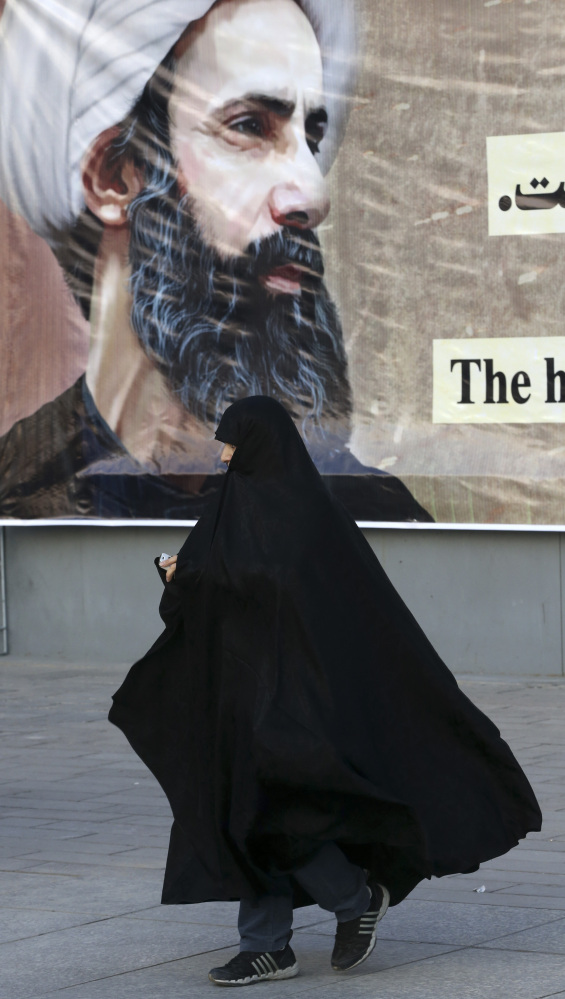 An Iranian woman walks past a portrait of Sheikh Nimr al-Nimr, who was executed by Saudi Arabia last week)