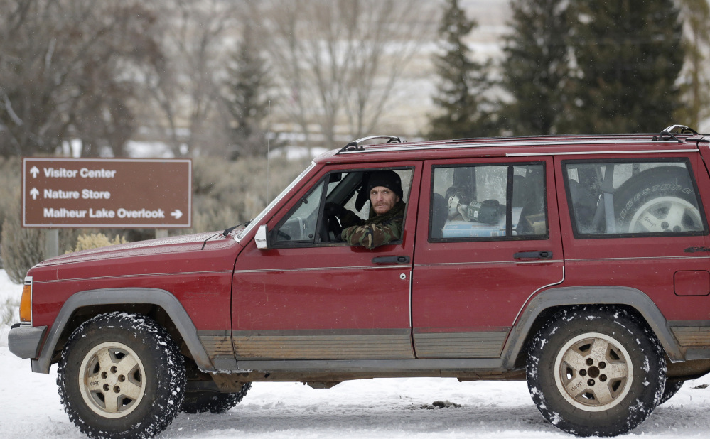 A member of the group occupying the Malheur National Wildlife Refuge headquarters drives near the front entrance Tuesday. (The Associated Press)
