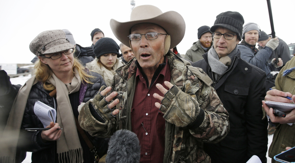 LaVoy Finicum, a rancher from Arizona who is part of the group occupying the Malheur National Wildlife Refuge, speaks with reporters at the the refuge Tuesday near Burns, Ore. Law enforcement had yet to take any action against the group of about two dozen people who are upset over federal land policy.