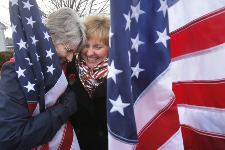 Freeport flag lady Elaine Greene, left, gets a hug from Maine first lady Ann LePage Dec. 22. A reader says James Roux III, who objects to the group’s pro-military message linked to the Sept. 11 attacks, is often portrayed unfairly.