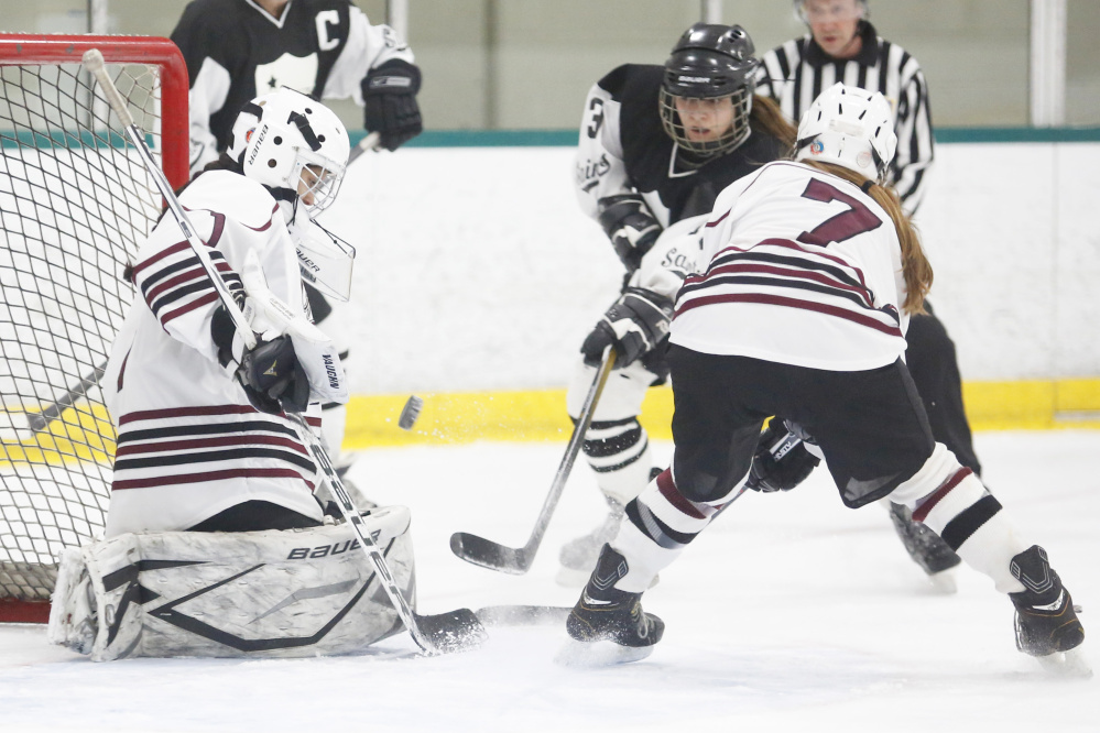 Greely’s Nica Todd makes a save on Lexie Kesaris of St. Dom’s in Wednesday night’s game at Falmouth. Todd gets some help in front of the net from Bridget Roberts, who scored the winning goal in the third period.
