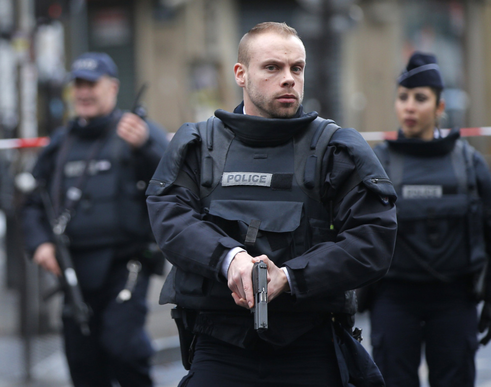 Paris police secure the scene of a fatal shooting at a police station Thursday. French officials say a man armed with a knife was shot to death by officers in northern Paris.
