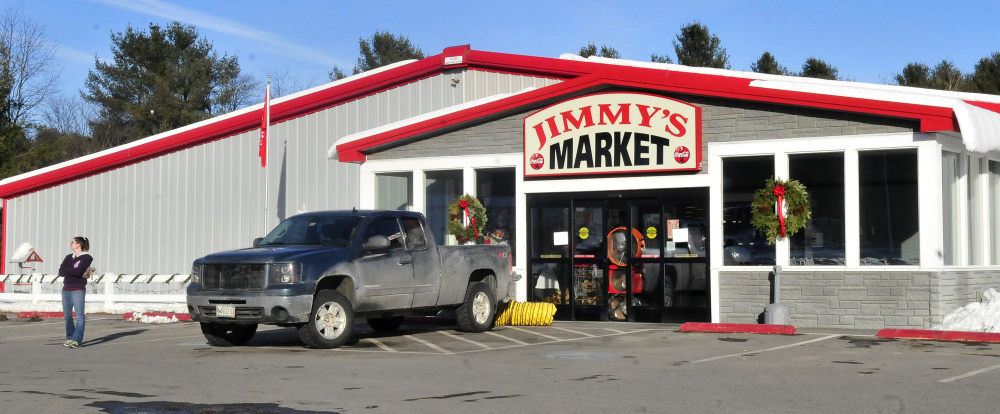 An employee stands outside Jimmy’s Market in Bingham as large fans ventilate it Wednesday after a small fire.