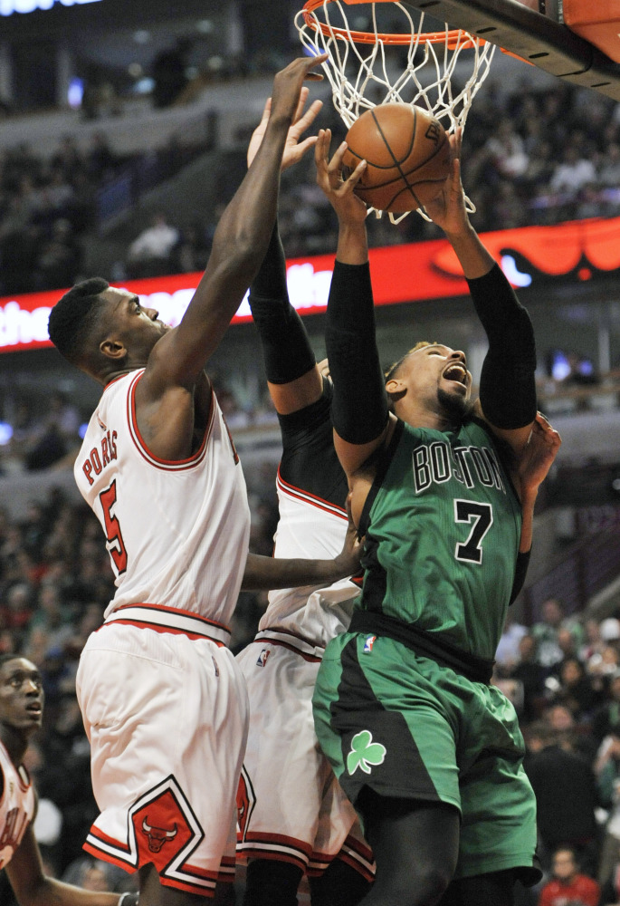 Boston Celtics' Jared Sullinger goes up for a shot against Chicago Bulls' Bobby Portis and Taj Gibson in the first half  Thursday in Chicago. The Associated Press