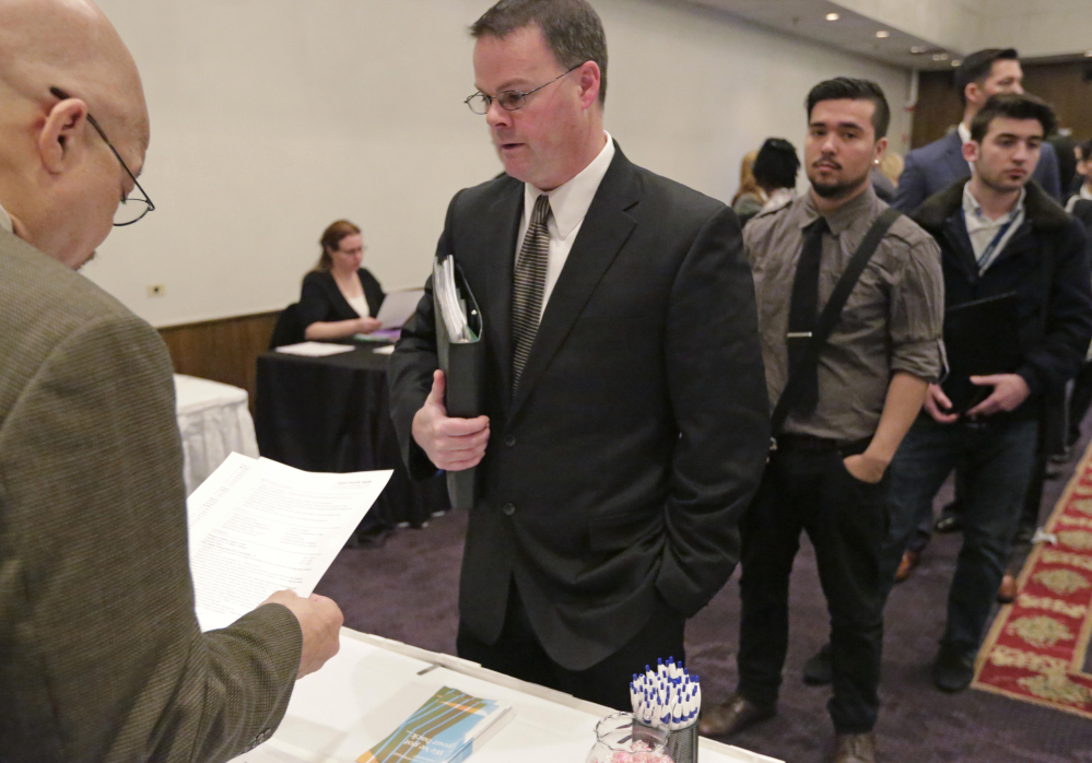 James Smith, center, leads a pack of job applicants at a National Career Fairs event in Chicago last April. U.S. employers added 2.65 million jobs in 2015, a monthly average of 221,000. It was the second-best year for hiring since 1999, after 2014.