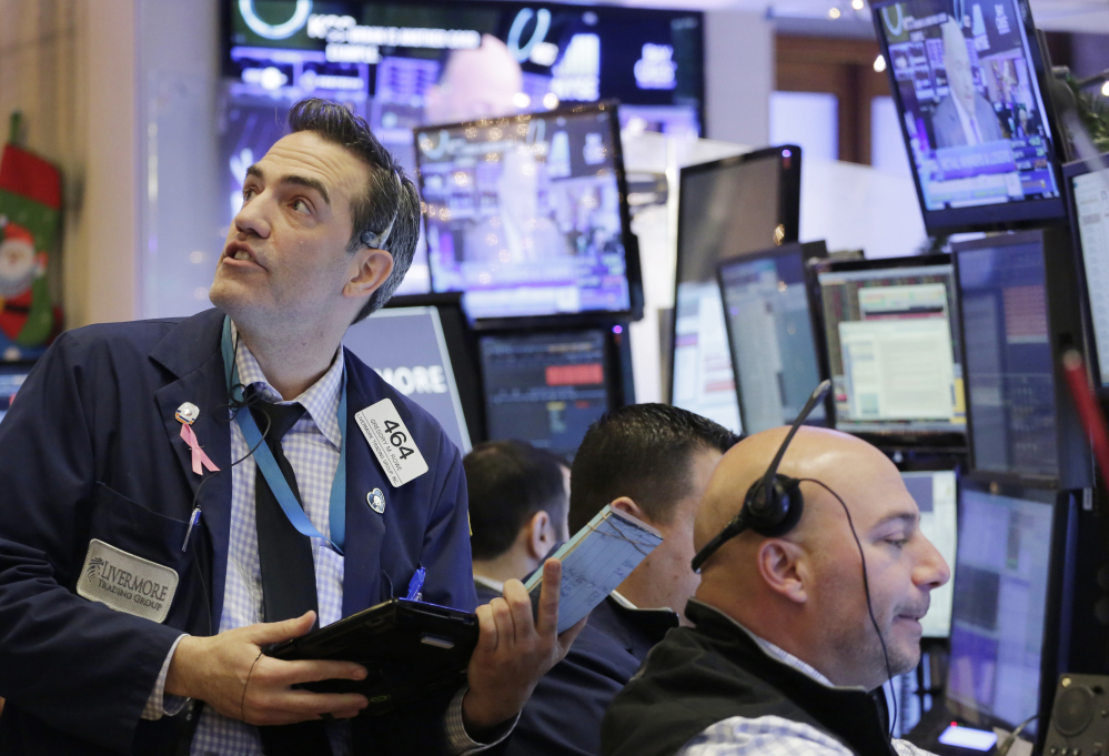 Gregory Rowe, left, with Livermore Trading Group, keeps an eye on stock prices at the New York Stock Exchange on Friday.