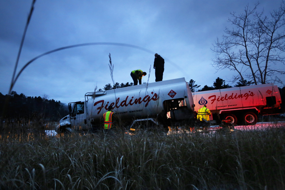 Crews work at the scene of a truck crash and oil spill near the Harraseeket River in Freeport on Friday.