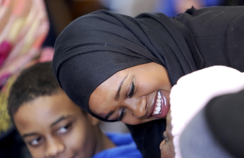 Zahra Abu speaks with family members Friday before her swearing-in ceremony at Portland City Hall. Five new members joined the Portland Police Department, including Abu, Maine’s first Somali officer.