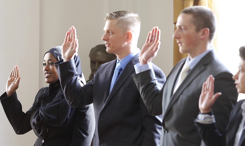 Zahra Abu, left, is sworn in along with Darrel Gibson, David Moore and Concetta Puleo during Friday’s ceremony at Portland City Hall. Abu is Portland’s first Somali officer.