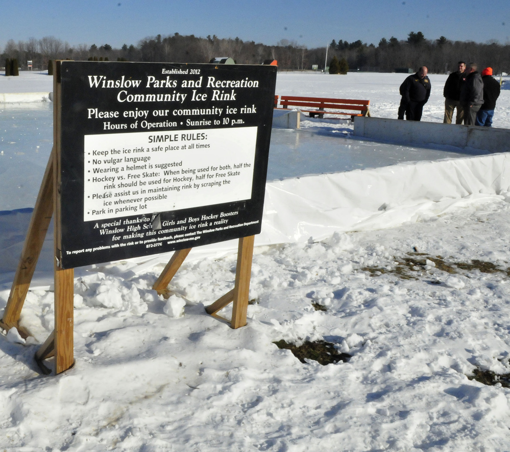 Contributors talk about creating an outdoor ice skating rink Thursday in Winslow. The rink opens Saturday.