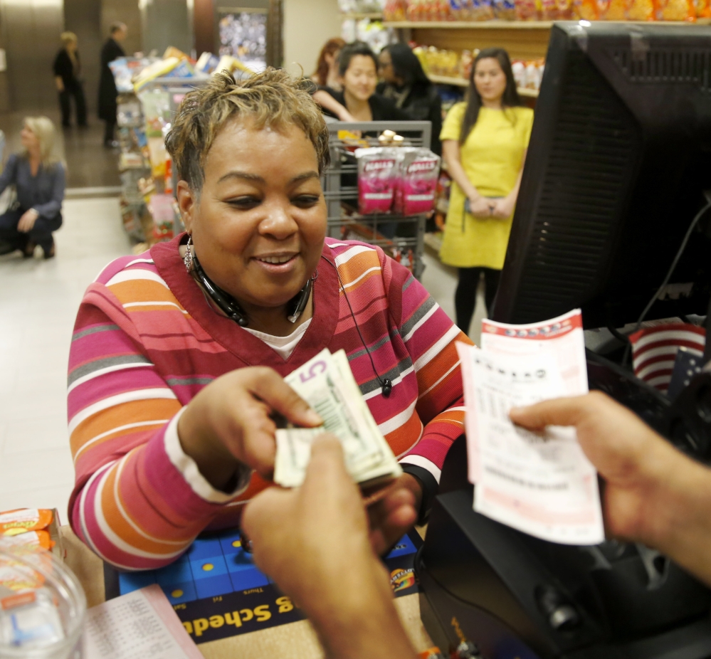 Anita Goodwin from Hammond, Ind., buys Powerball tickets from Biren Shah in Chicago as the multi-state jackpot reached $800 million Friday. 