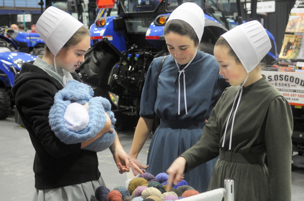 Lilia, left, Cassia and Moriah Higgins inspect yarn on display on the first day of the Agricultural Trades Show at the Augusta Civic Center.