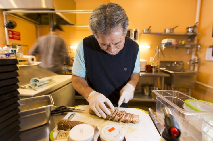 Kei Suzuki, owner of Ramen Suzikaya, slices roasted pork in preparation for the lunch rush in 2016.