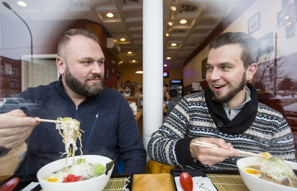 Saco residents Kyle Holmquist, left, and Bradley De Rosa dig into bowls of ramen from their window seats at Ramen Suzikaya on Congress Street in Portland.
