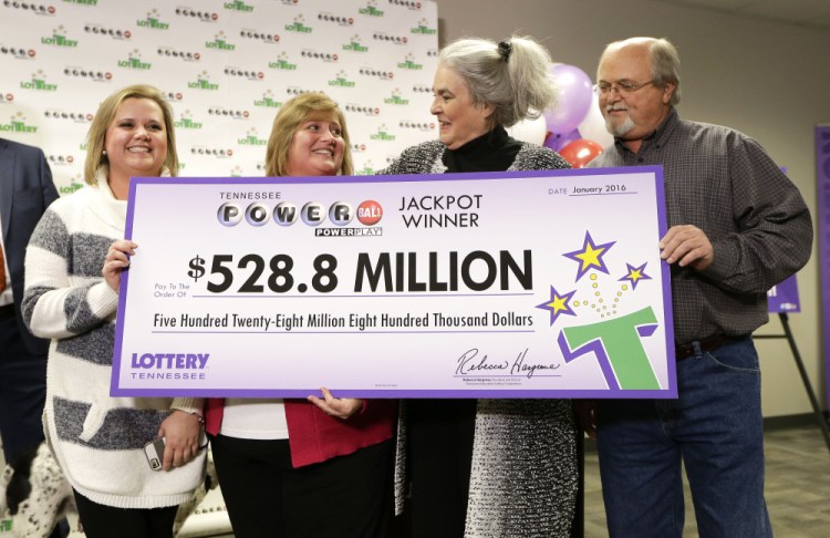 Rebecca Hargrove, second from right, president and CEO of the Tennessee Lottery, presents a ceremonial check to John Robinson, right; his wife, Lisa, second from left; and their daughter, Tiffany, left, after the Robinson’s winning Powerball ticket was authenticated at the Tennessee Lottery headquarters Friday in Nashville, Tenn.