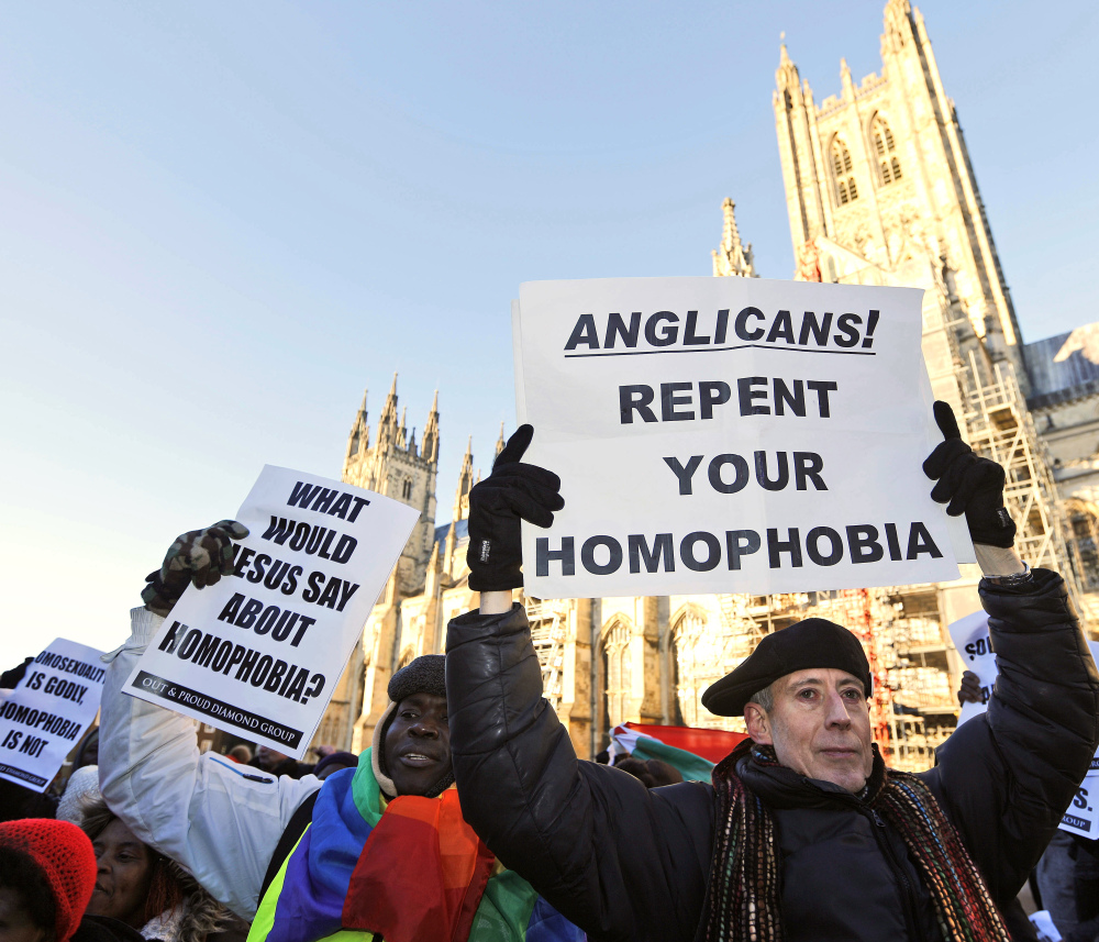 Human rights campaigners in Canterbury, England, demonstrate on Friday against the decision by Anglicans to punish pro-gay marriage Episcopal churches in America.