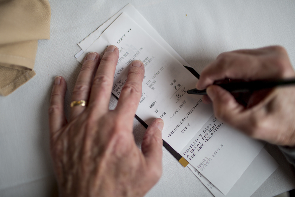 Richard Greenleaf of Gorham fills in the tip amount on a check after eating lunch with friends at DiMillo's On the Water Friday.
Gabe Souza/Staff Photographer